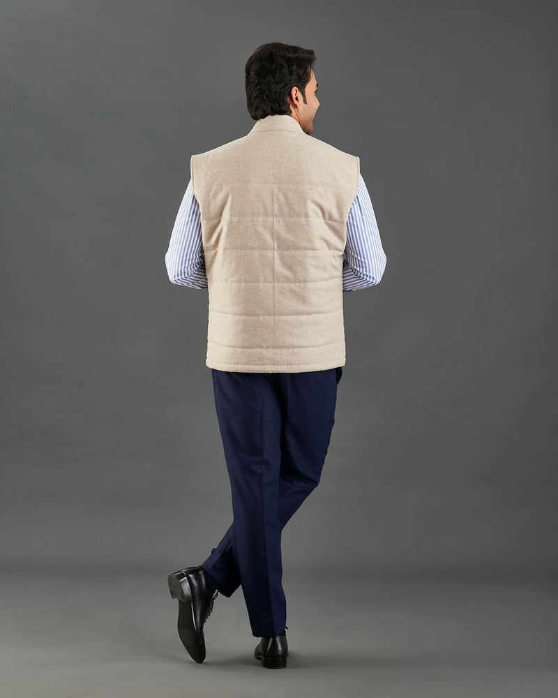 Back of model wearing the flannel quilted vest for men by Luxire in ecru hands in pockets hands in pockets